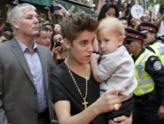 Benabou (de traje gris, atrás de Bieber) pide compensaciones no especificadas por los daños de agresión y violencia y un pago de 421 mil 261 dólares